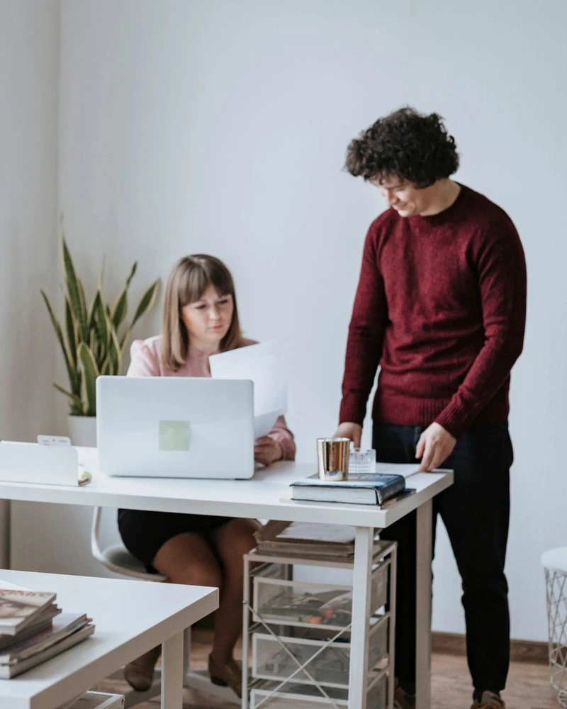 A small team at work in a bright office, one of them at a laptop